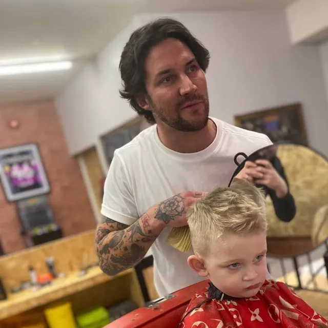 A barber cutting a young boy’s hair