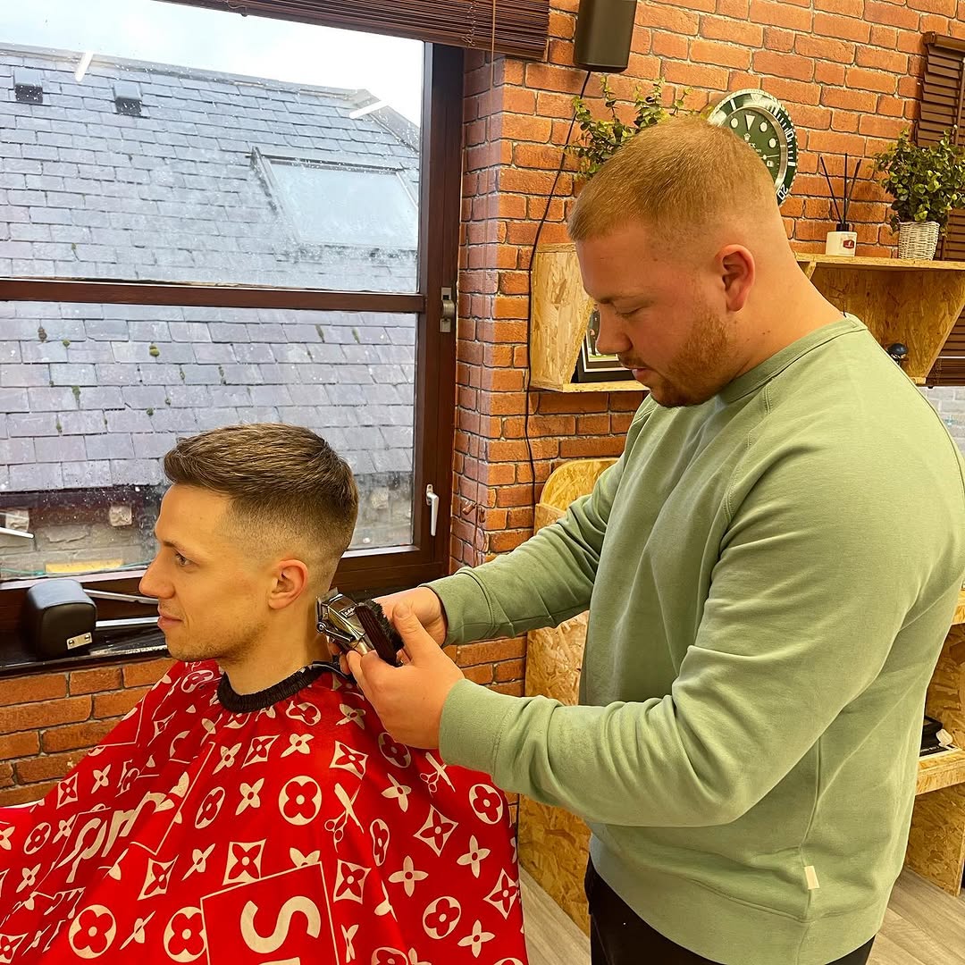A Black Dog barber blending a skin fade with clippers